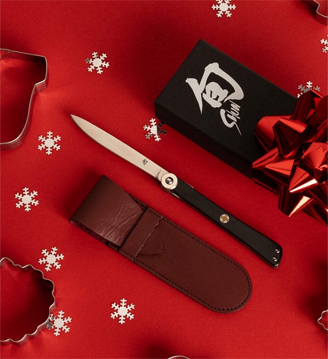 A personal steak knife lies next to its case.