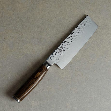 Premier Nakiri knife on a light stone surface.