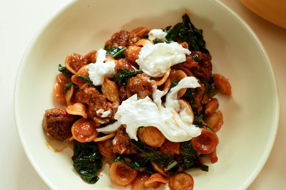 Close up of bowl full of crispy orecchiette with sausage.
