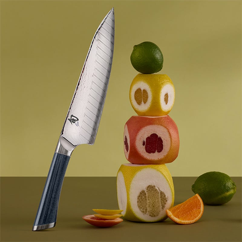 Shun Shiranami 8-inch chef’s knife with Damascus blade beside stacked citrus fruits