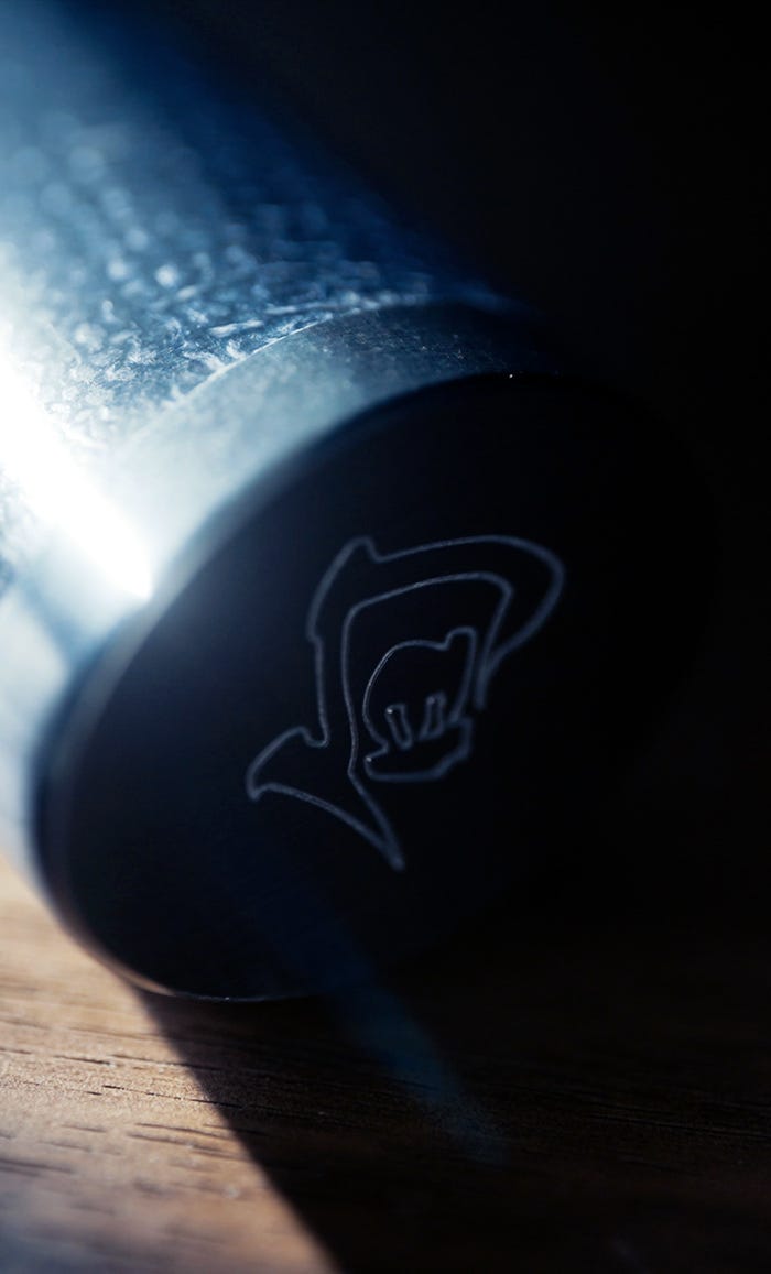 Close-up of embossed Shun logo on the endcap of a Shiranami knife handle