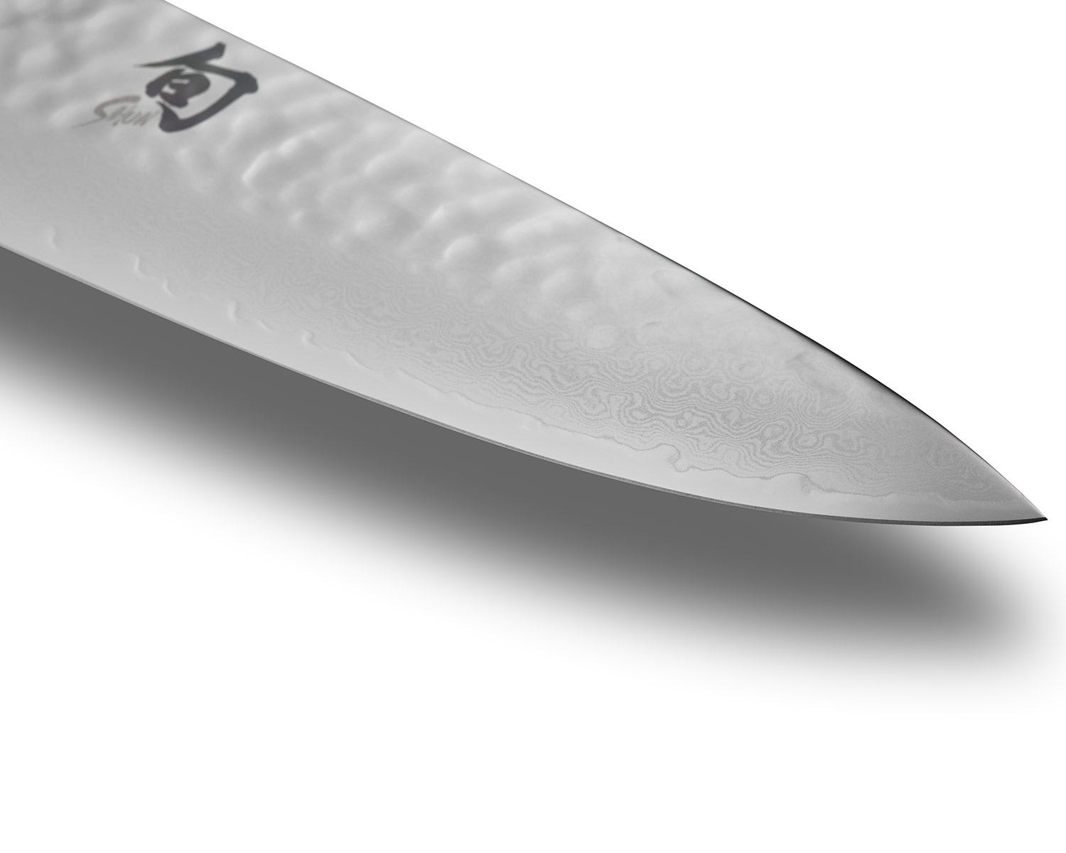 Close-up of a Shun knife blade showing refined edge geometry and layered Japanese steel craftsmanship.
